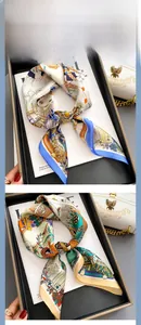 Detailed view of silk scarf with giraffe print and elegant floral patterns in gift box