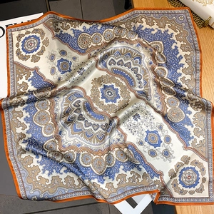 Detailaufnahme von Paisley Seidenschal mit orangefarbenem Saum und glänzendem Stoff