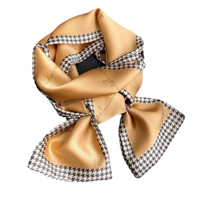 Elegant mustard yellow and black silk scarf with houndstooth print and artistic text