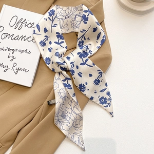 Écharpe fine en soie avec motifs floraux bleus sur une veste de costume beige
