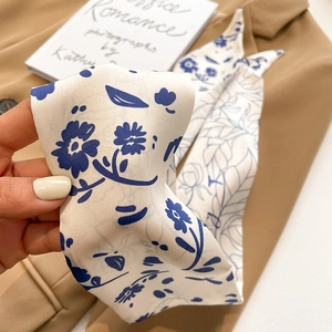 Vue détaillée du ruban en soie crème avec motif floral vintage bleu marine sur satin