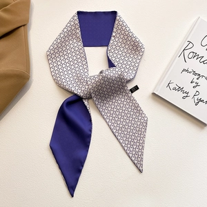 Détail d'un foulard étroit en soie avec motifs étoilés et finition en satin violet