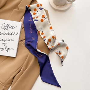 Détail d'un foulard twilly en soie double face stylisé sur un blazer pour look de bureau