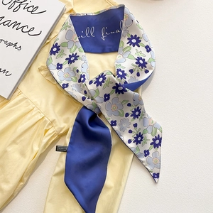 Foulard en soie à fleurs bleu foncé style français sur un chemisier jaune clair