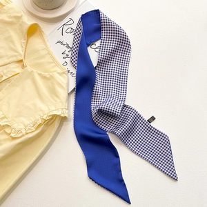 Détail d'un foulard twilly bleu roi et vichy assorti à une chemise jaune à volants