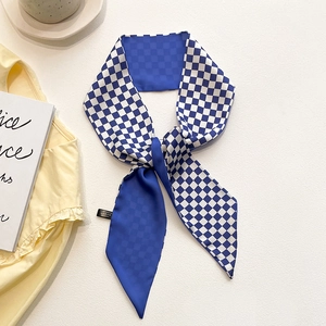 Détail d'un foulard en soie à damier bleu et blanc avec des extrémités pointues en satin