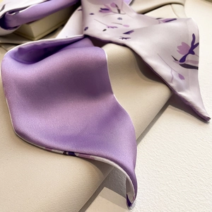 Detailopname van lila zijden sjaal met bloemenprint op elegante satijnen stof
