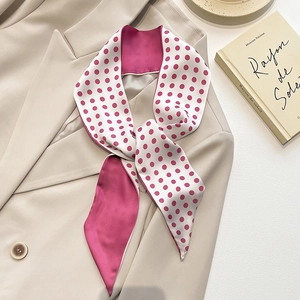 Roze zijden sjaal met witte stippen gedragen als stropdas op een beige blazer