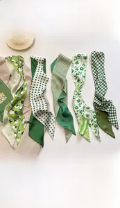 Detail of five green and white patterned twilly scarves for bags and hair accessories