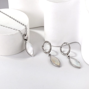 Detailed view of silver stainless steel jewelry set with white shell butterfly motifs