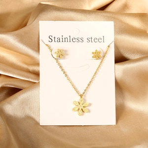 Ensemble bijoux collier et boucles d'oreilles fleur dorée en acier inox sur soie
