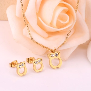 Parure collier et boucles d'oreilles hibou doré avec cristaux sur fond de roses