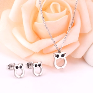 Parure bijoux hibou avec collier et boucles d'oreilles sur fond de rose tendre