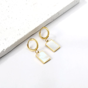 18K gold plated stainless steel rectangle white shell drop earrings on a stone platform