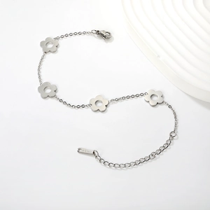 Détail macro du bracelet en acier inoxydable argenté avec breloques fleurs évidées