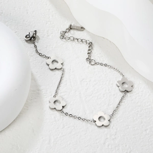 Détail du bracelet en acier inoxydable argenté avec quatre breloques de fleurs creuses