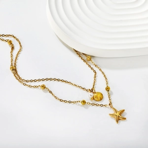 Double-layered gold necklace with starfish, seashell pendants and white pearl on wave stand