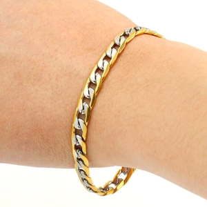 Bracelet pour homme en acier inoxydable bicolore argent et or porté sur un poignet masculin