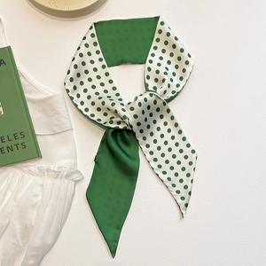 Detail of green and white polka dot silk scarf tied on a handle with French style