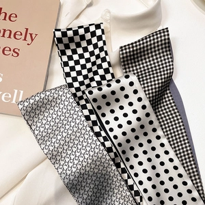 Detail of four elegant silk scarves with checkerboard and polka dot patterns on a shirt