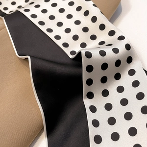 Close-up of minimalist black and white polka dot satin silk scarf with refined edges