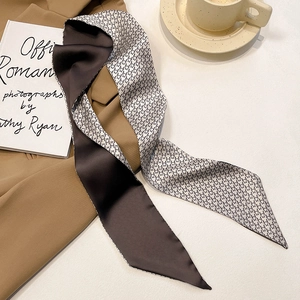 Close-up of double-sided silk skinny scarf with star pattern on a warm desktop