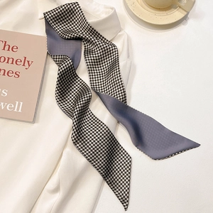 Detail of grey and checkered skinny silk scarf styled on a white professional shirt
