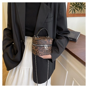 Detailed view of leopard print mini cylindrical box bag with silver metal zipper closure