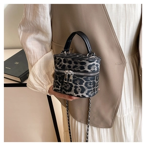 Detail of leopard print cylinder bag with silver chain and dual zipper closure system