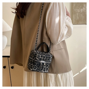 Detailed view of leopard print mini box bag with metallic chain and dual zipper closure