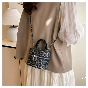 Detail of leopard print bucket bag with silver chain strap and double zipper closure