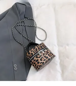 Detailed view of leopard print cylinder mini bag with silver double zipper and metal chain