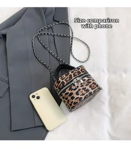 Mini leopard print bucket bag with silver chain next to a smartphone for size reference