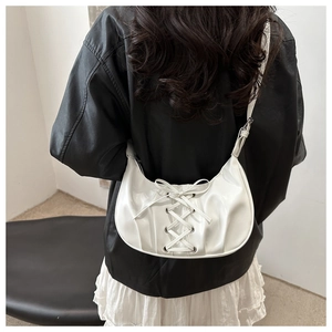 Détail du sac demi-lune blanc avec rubans croisés style corset et œillets argentés