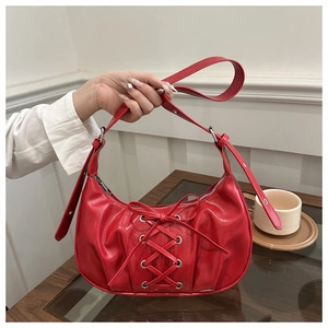 Détail du sac hobo demi-lune rouge avec laçage corset et un nœud décoratif élégant