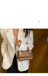 Detail of color-block crossbody bag featuring metal letter D and silk scarf handle