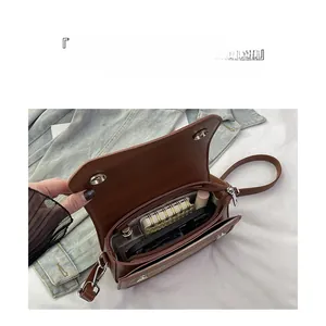 Detail of spacious interior compartments in a brown crossbody bag for daily essentials