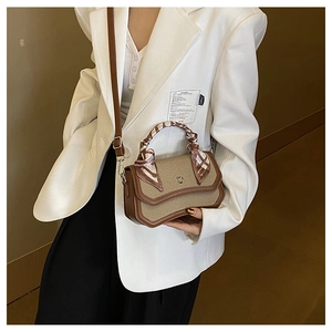 Detail of woven patchwork crossbody bag with metal D buckle and silk scarf handle