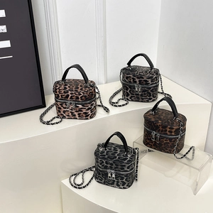 Modern leopard print barrel bags in four colors with chain straps on geometric display