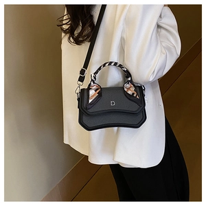 Detail of crossbody bag featuring printed silk scarf handle and silver D-letter hardware