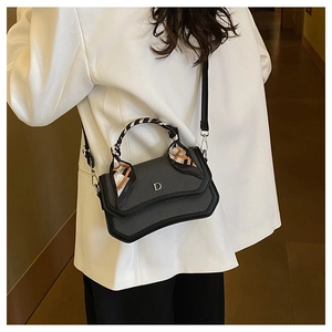 Detail of cross-body bag featuring contrasting textures and a decorative silk scarf