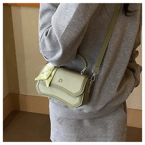 Detail of sage green crossbody bag with D-metal buckle and plaid silk scarf decoration