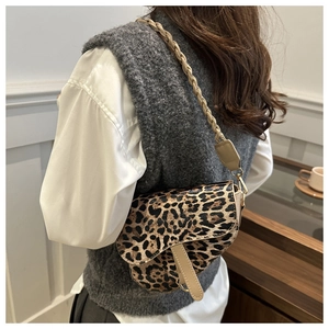 Détail du sac selle à imprimé léopard avec bandoulière tissée et finition en similicuir
