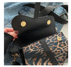 Détail du sac selle léopard avec fermoir magnétique doré sur veste en jean