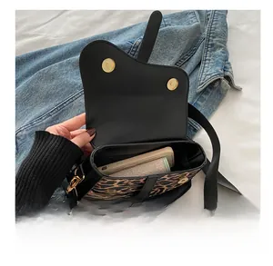 Détail montrant la capacité interne du sac selle à imprimé léopard pour les essentiels