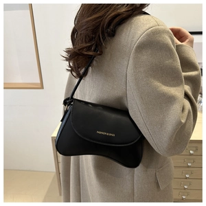 Close-up of black PU leather underarm bag with gold logo text on the curved flap