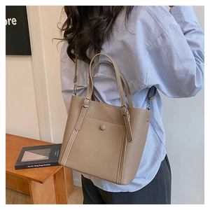 Detail of khakil leather tote bag with pebble texture and adjustable shoulder strap