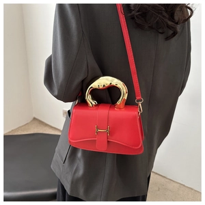 Rote Box-Tasche mit goldenem Griff und H-Verschluss, getragen von einem Model