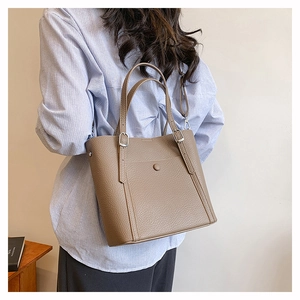 Detail of the litchi-textured brown leather tote with adjustable buckle handles
