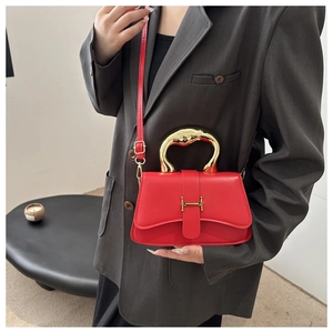 Detail der roten Leder-Handtasche mit goldener H-Schnalle und Metallgriff